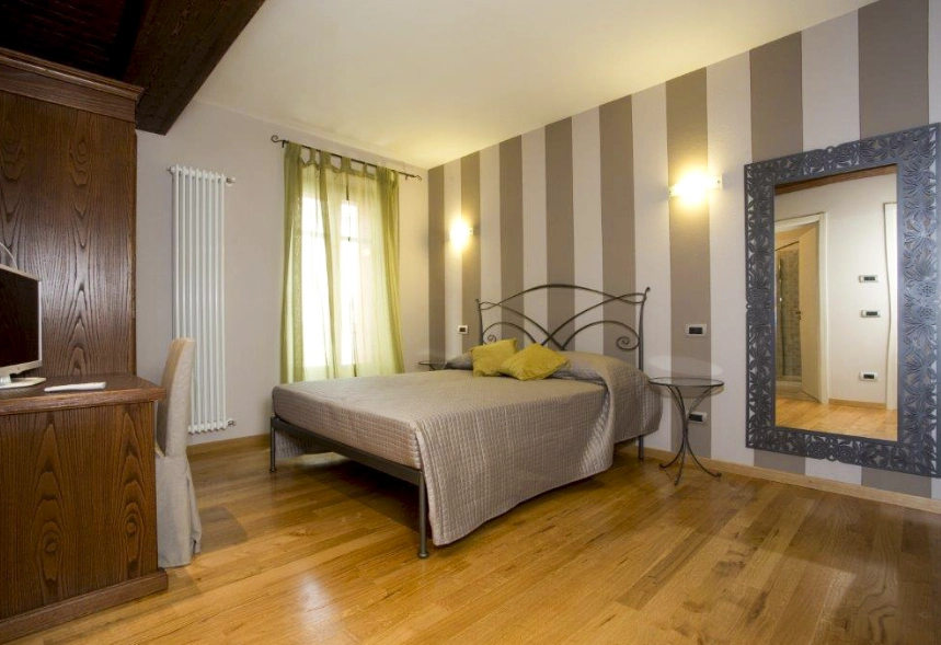 foto principale della camera Orchidea con un letto matrimoniale e una finestra